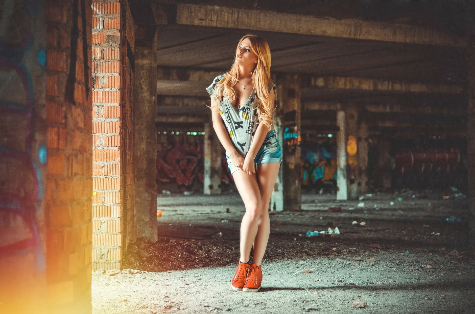 Откровенная блондинка позирует на фоне заброшенного здания