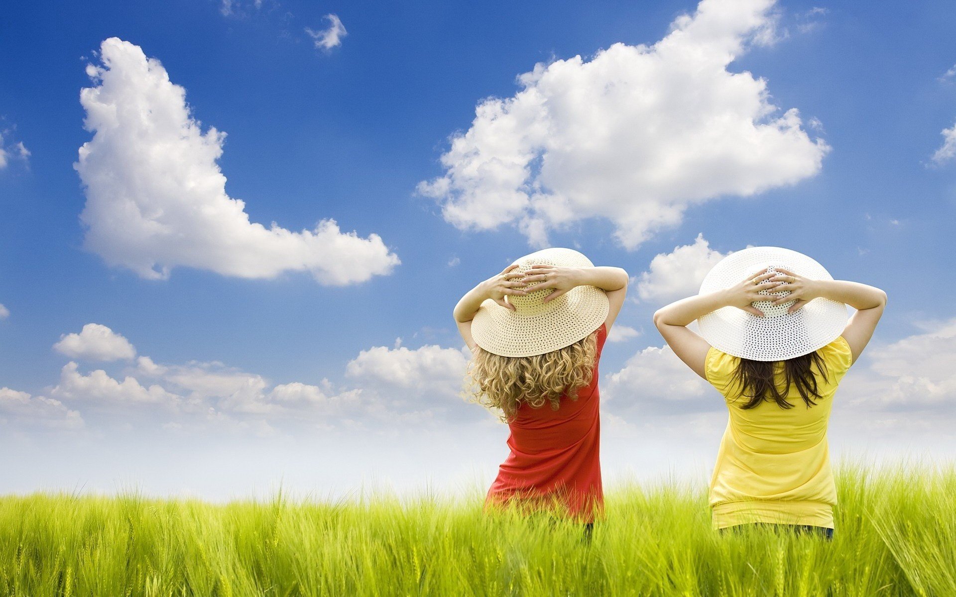 Девочки в соломенных шляпках на солнечном лугу