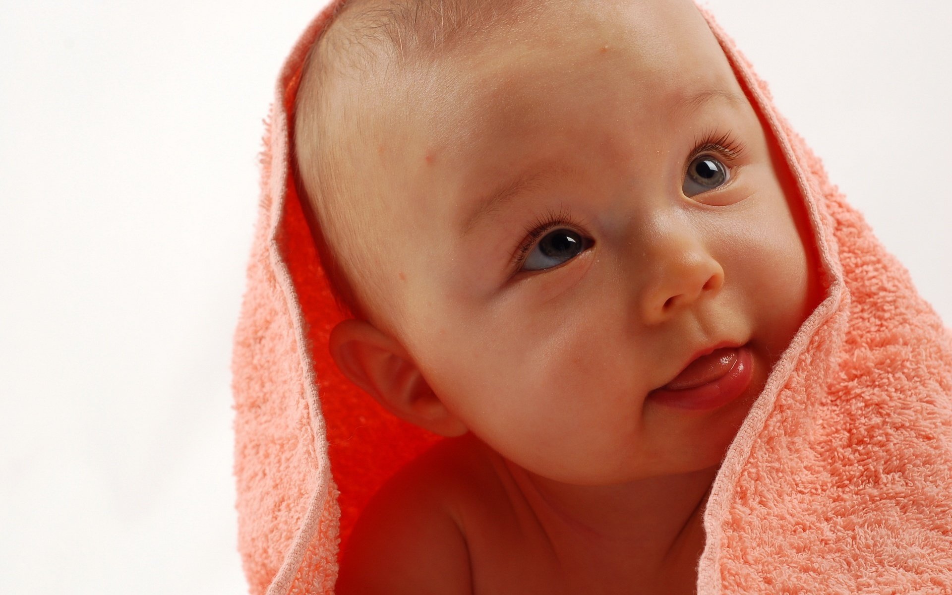 Улыбающийся ребёнок в розовом махровом полотенце
