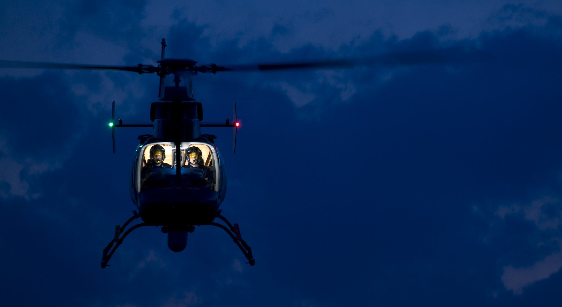 Вертолёт с освещённой кабиной завис в воздухе