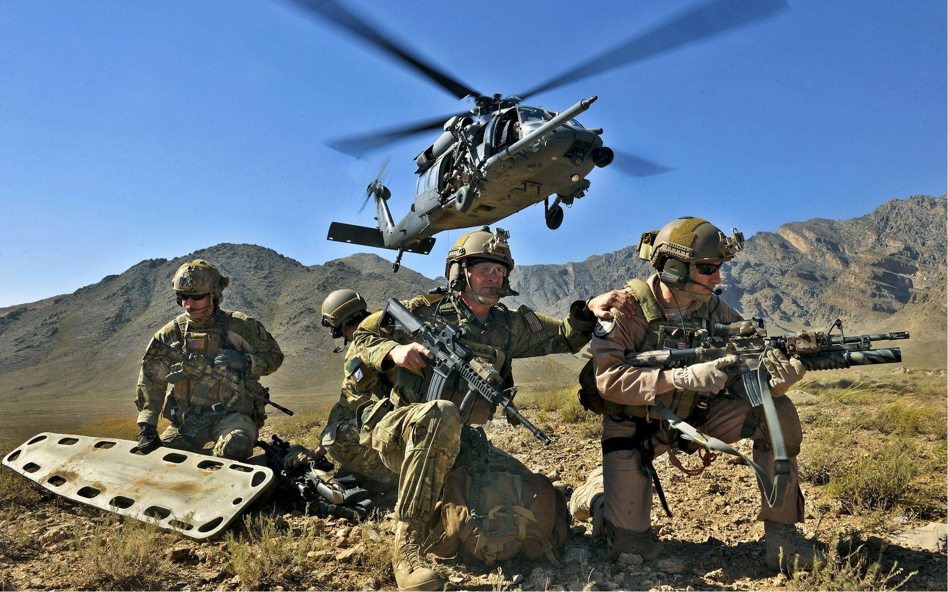 Трое солдат с носилкаии на фоне вертолёта