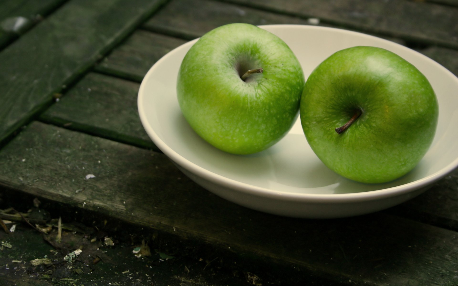 Два зелёных сочных яблока на тарелке