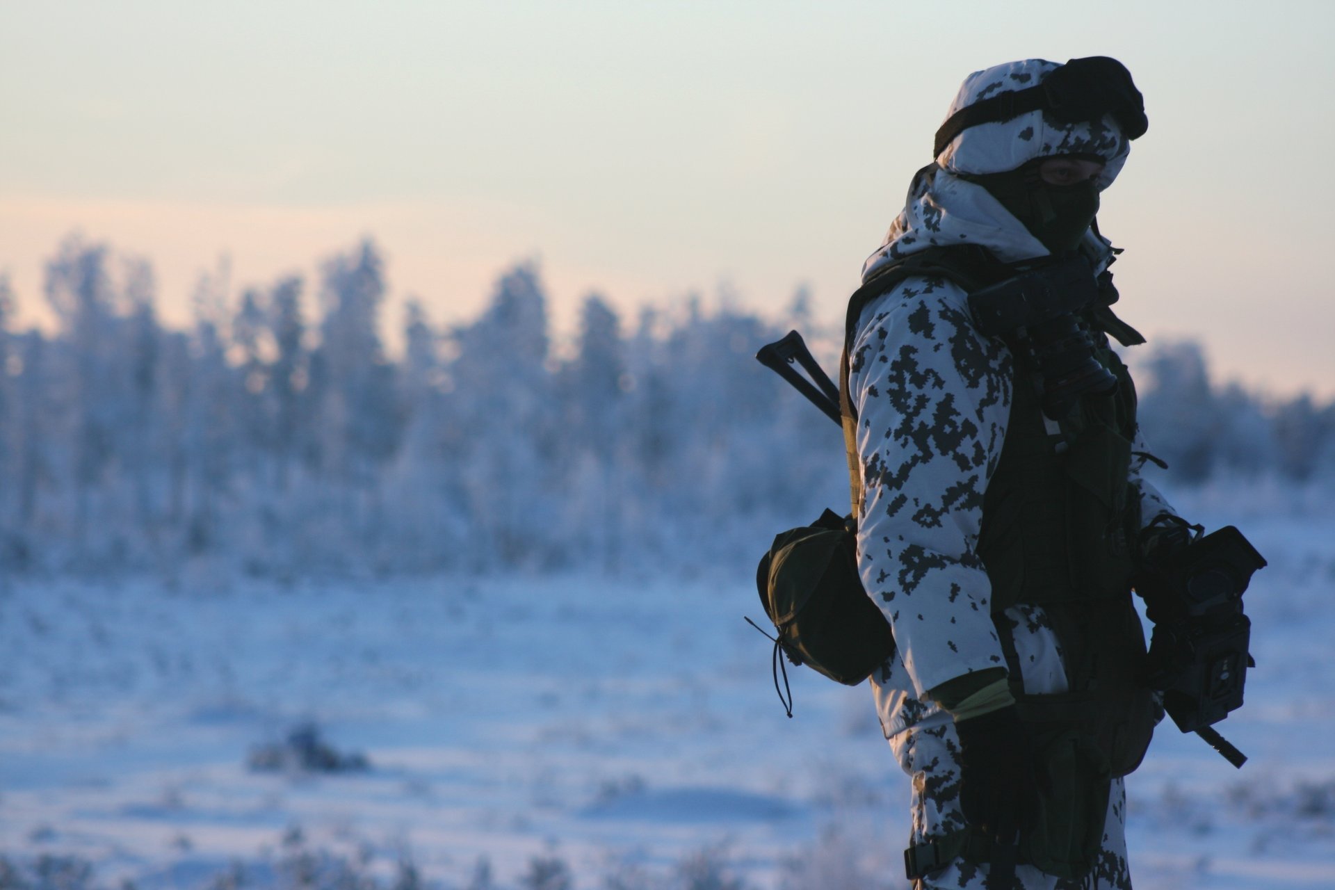 Солдат в зимнее поле с оружием