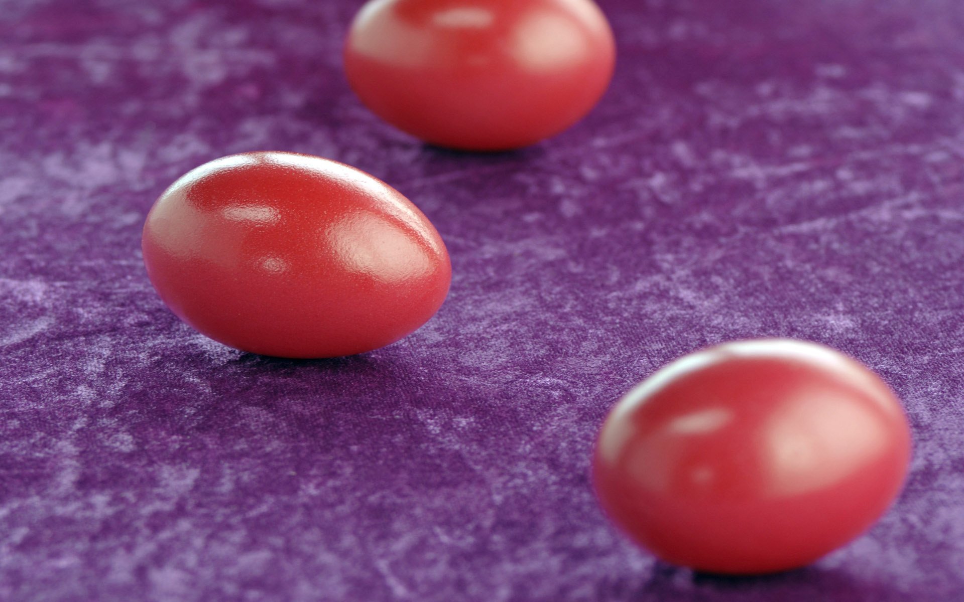 Красные яйца на фиолетовой салфетке