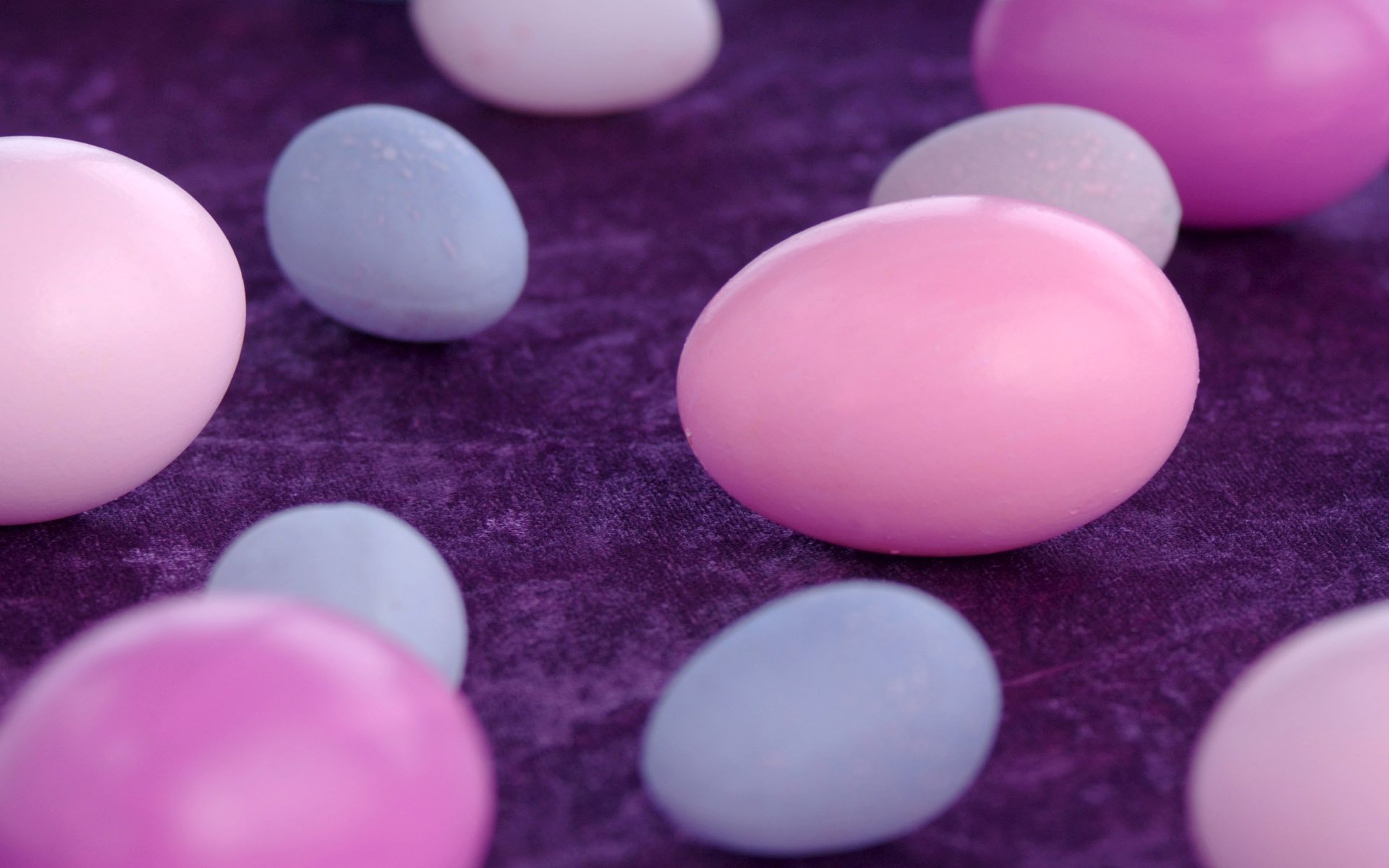 Разноцветные яйца на фиолетовой салфетке