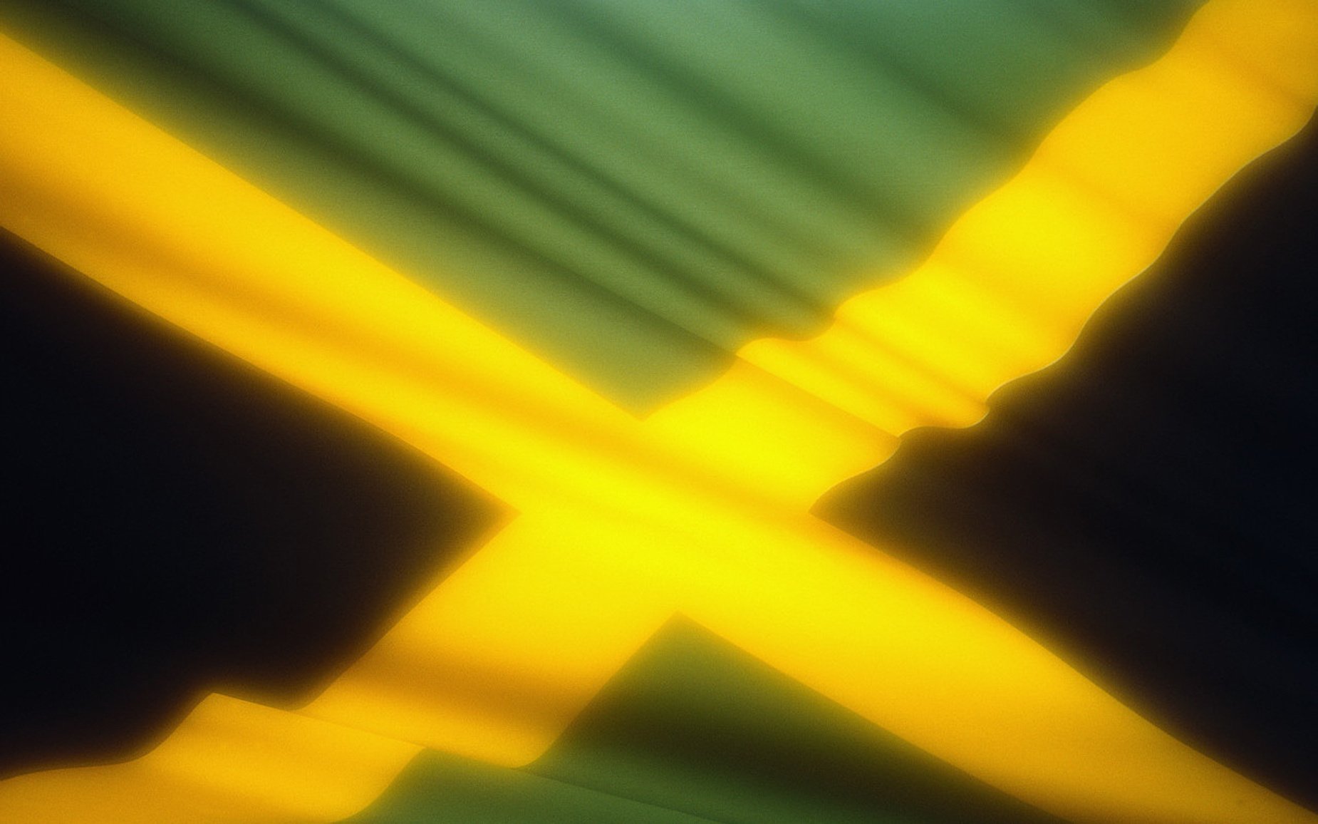 Изображение желто- зелёного флага Ямайки, развивающегося на ветру