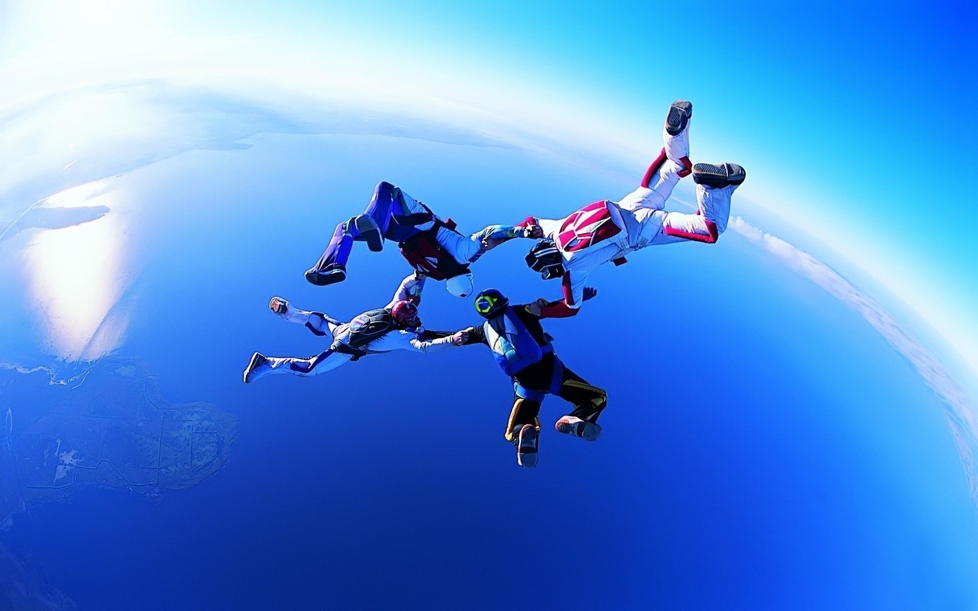 Полет четверки парашютистов в голубом небе