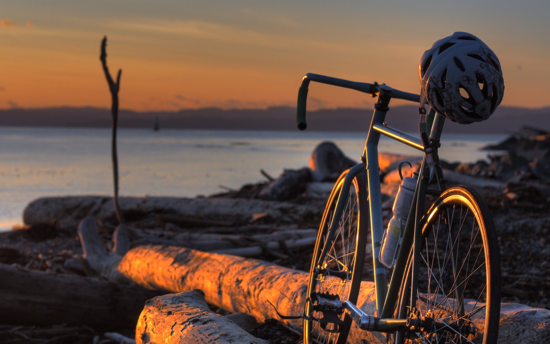 Велосипед на берегу стоит на бревнах