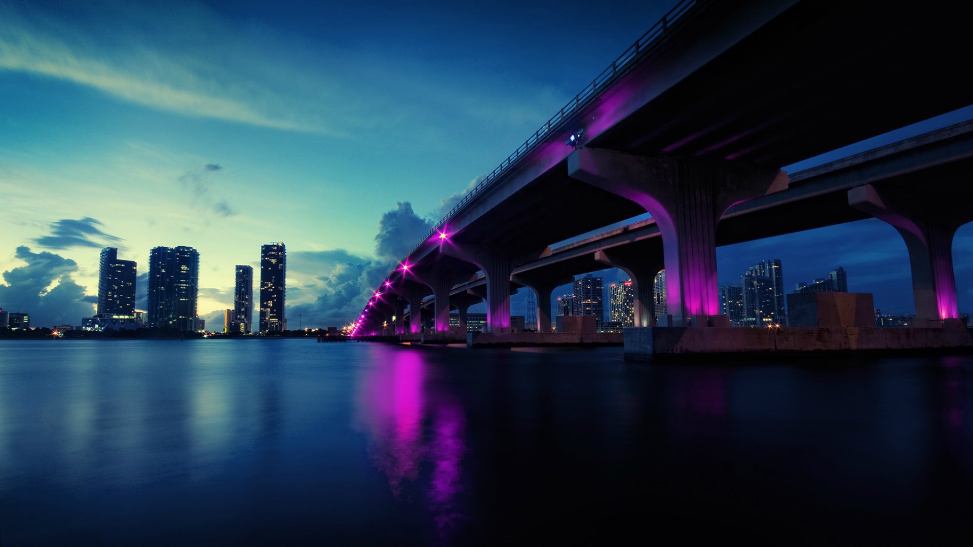 Вечерний мост с огнями малинового цвета над водой Обои на рабочий стол.