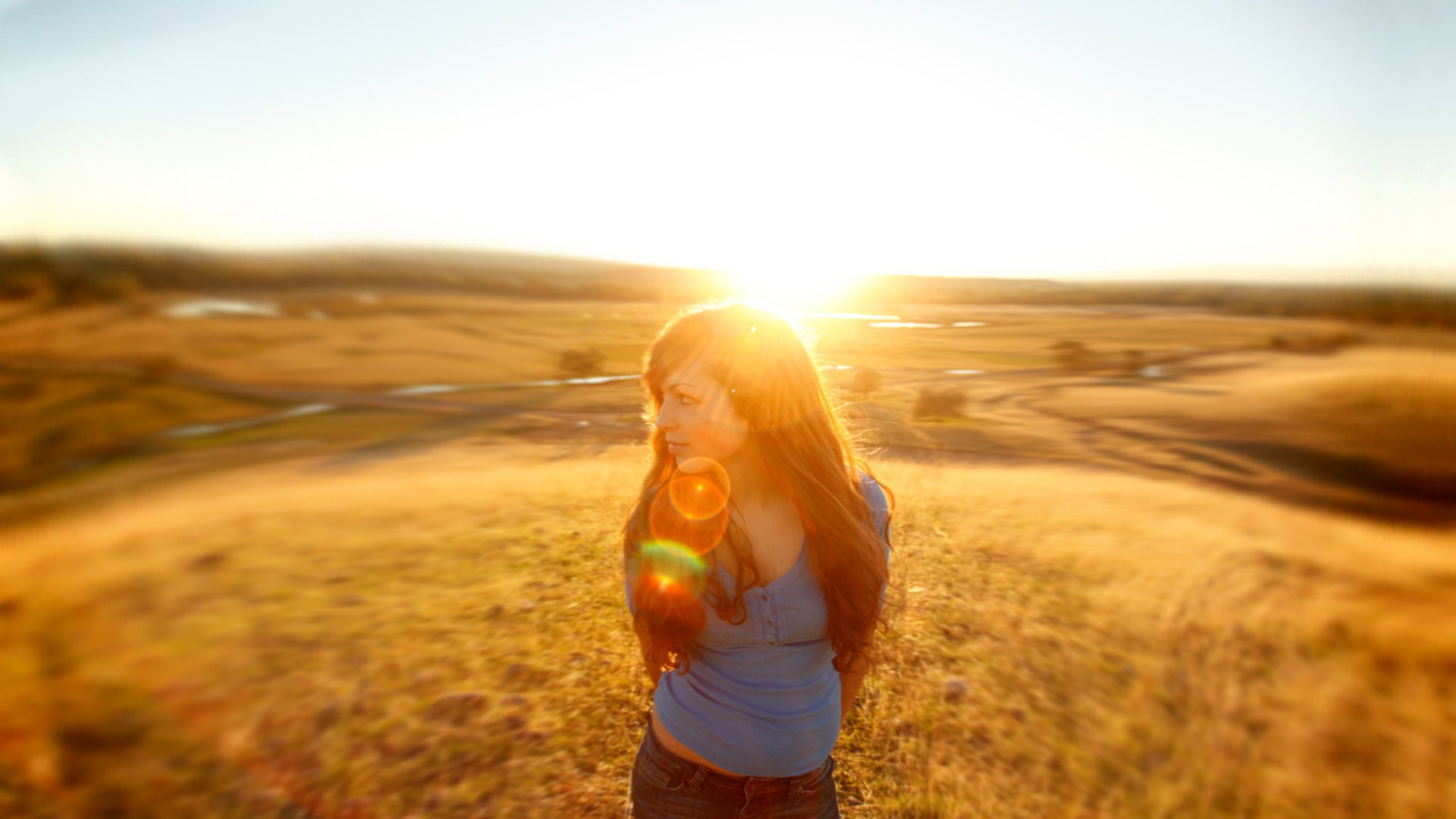 Девушка на фоне солнца в поле