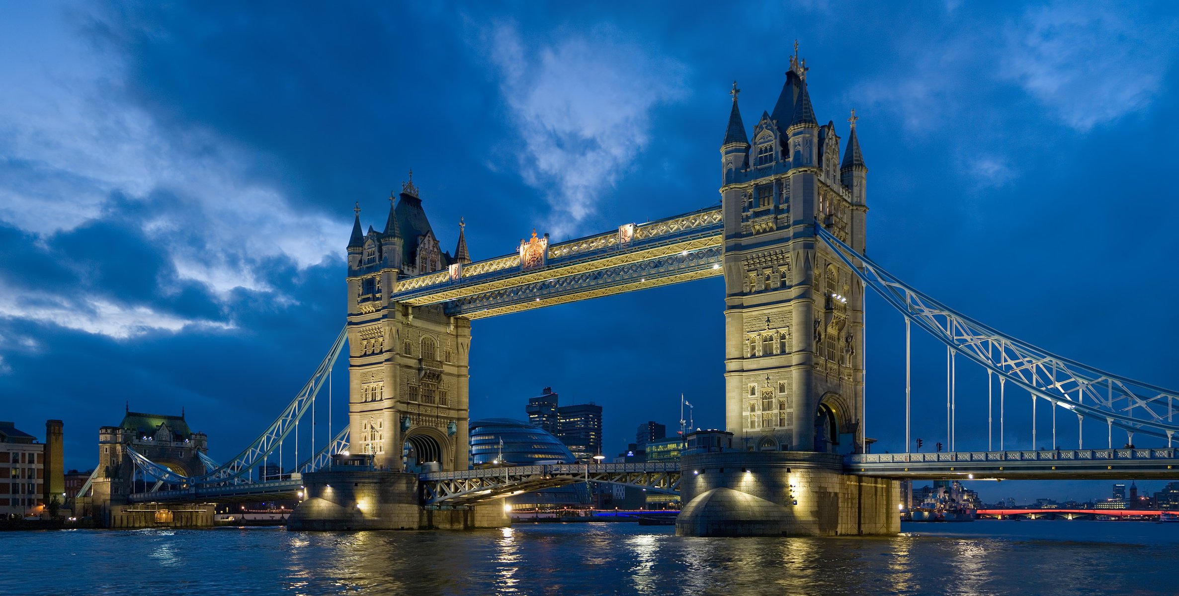 Лондонский Мост над рекой освещая воду