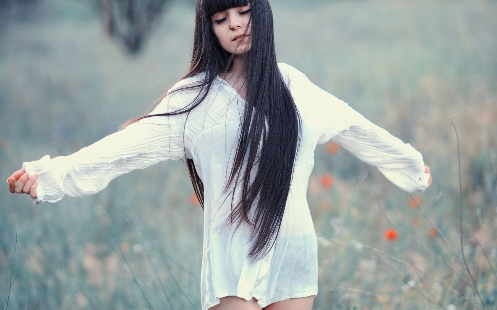 Девушка с длинными волосами в цветочном поле