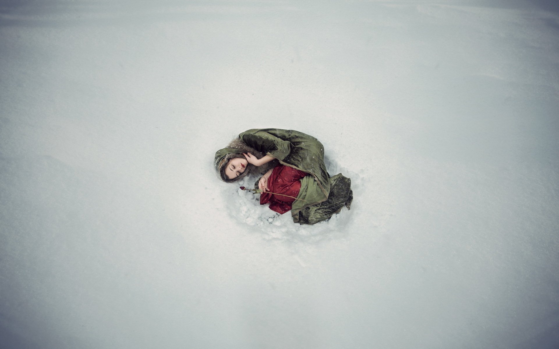 Девушка лежит на снегу