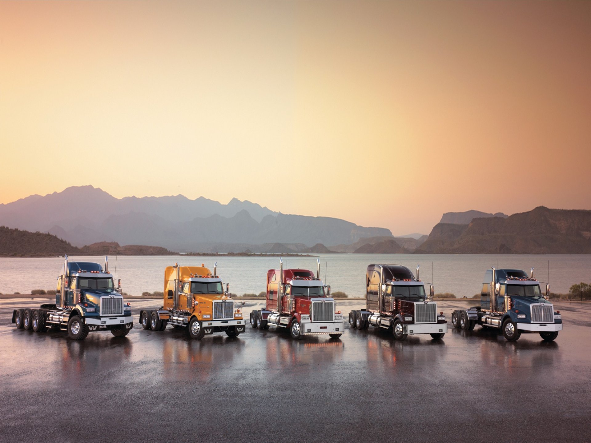 Пять грузовиков стоят на фоне залива и гор Обои на рабочий стол.