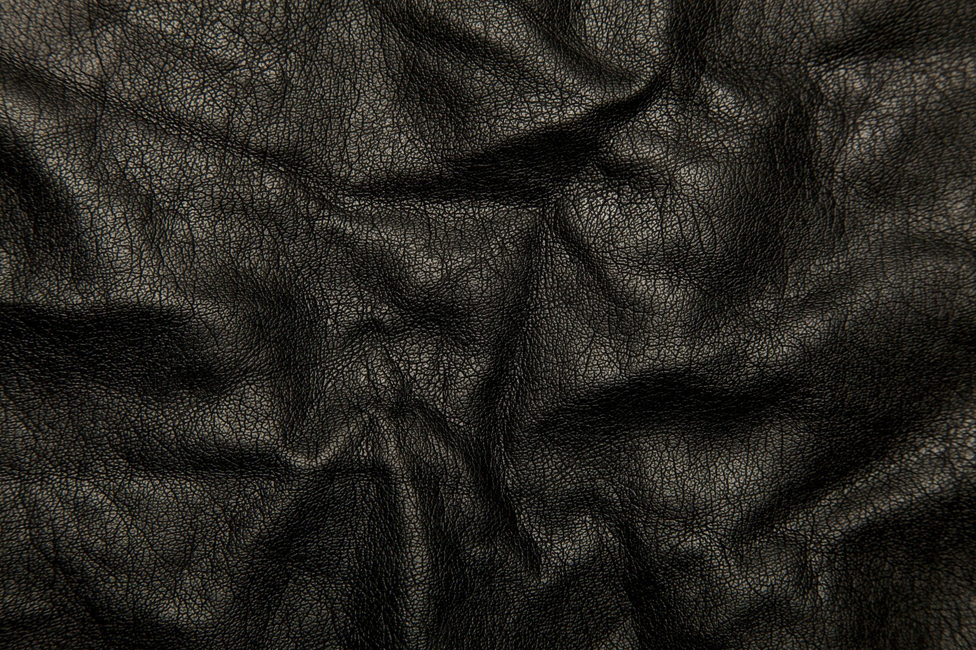 Складки на черной кожаной ткани