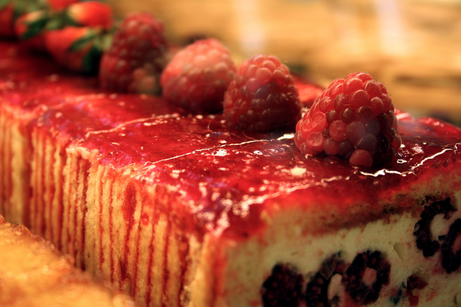 Пирожное с красным сиропом украшено свежей малиной