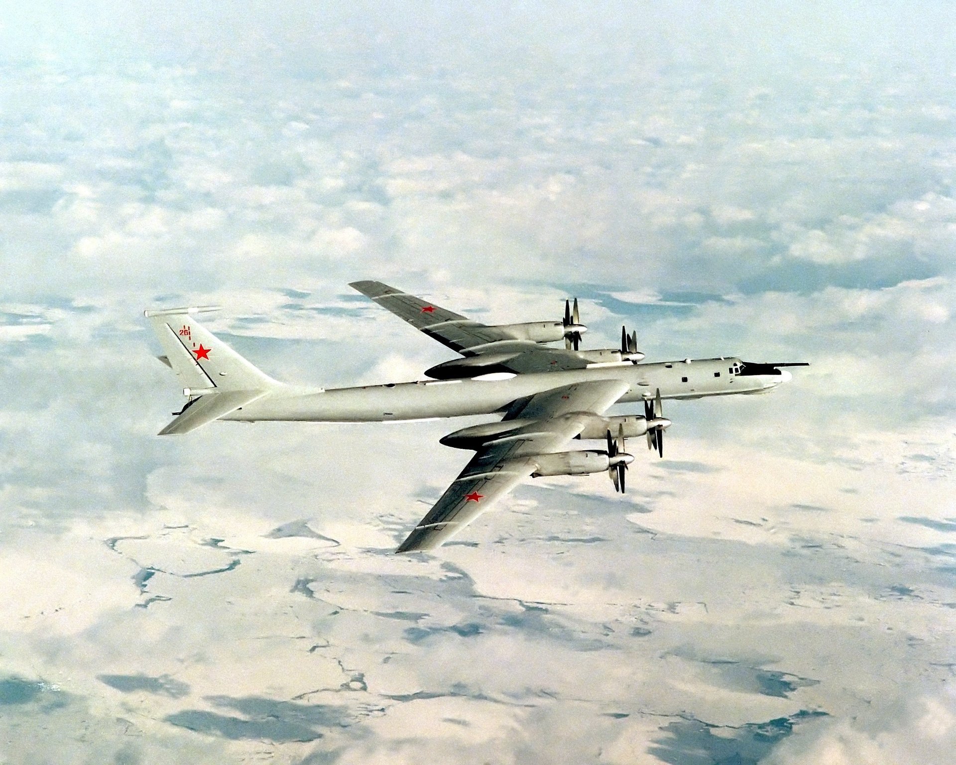 Советский самолёт летит над белыми облаками