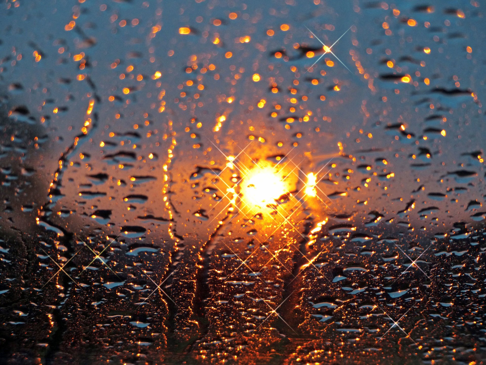 Капли дождя и закат на стекле