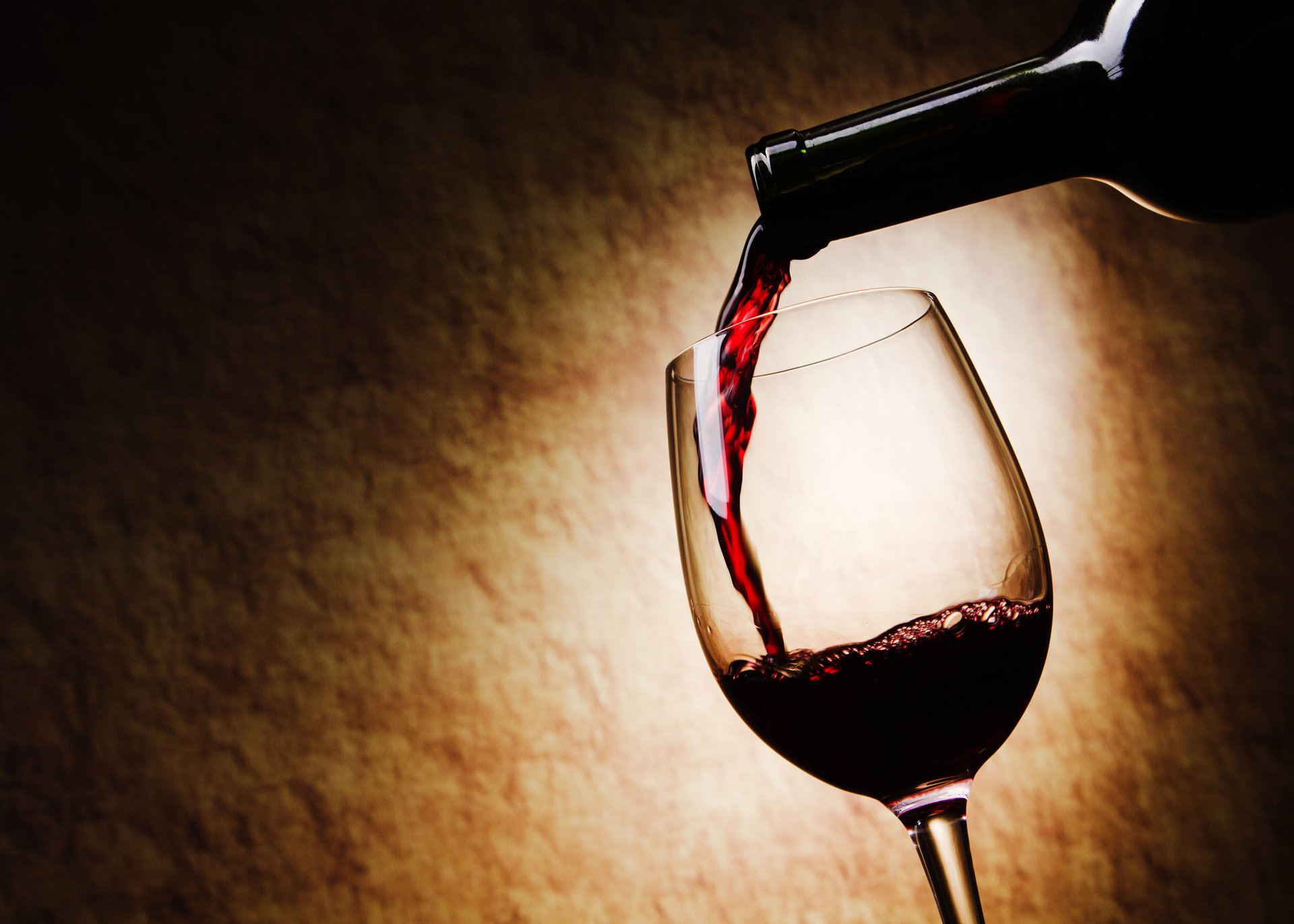 Красное вино наливается в бокал