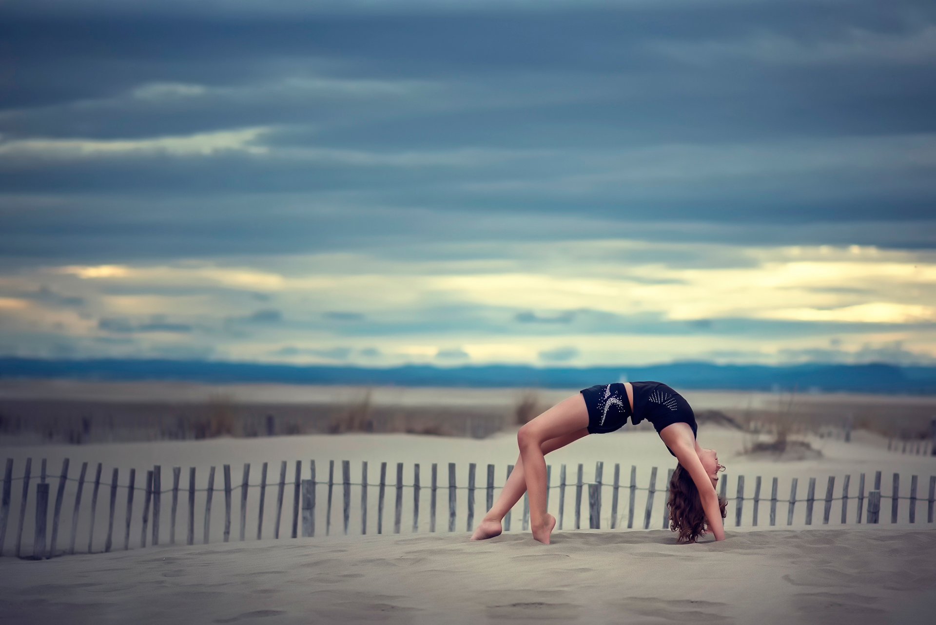 Девушка гимнастка на песке Обои на рабочий стол.