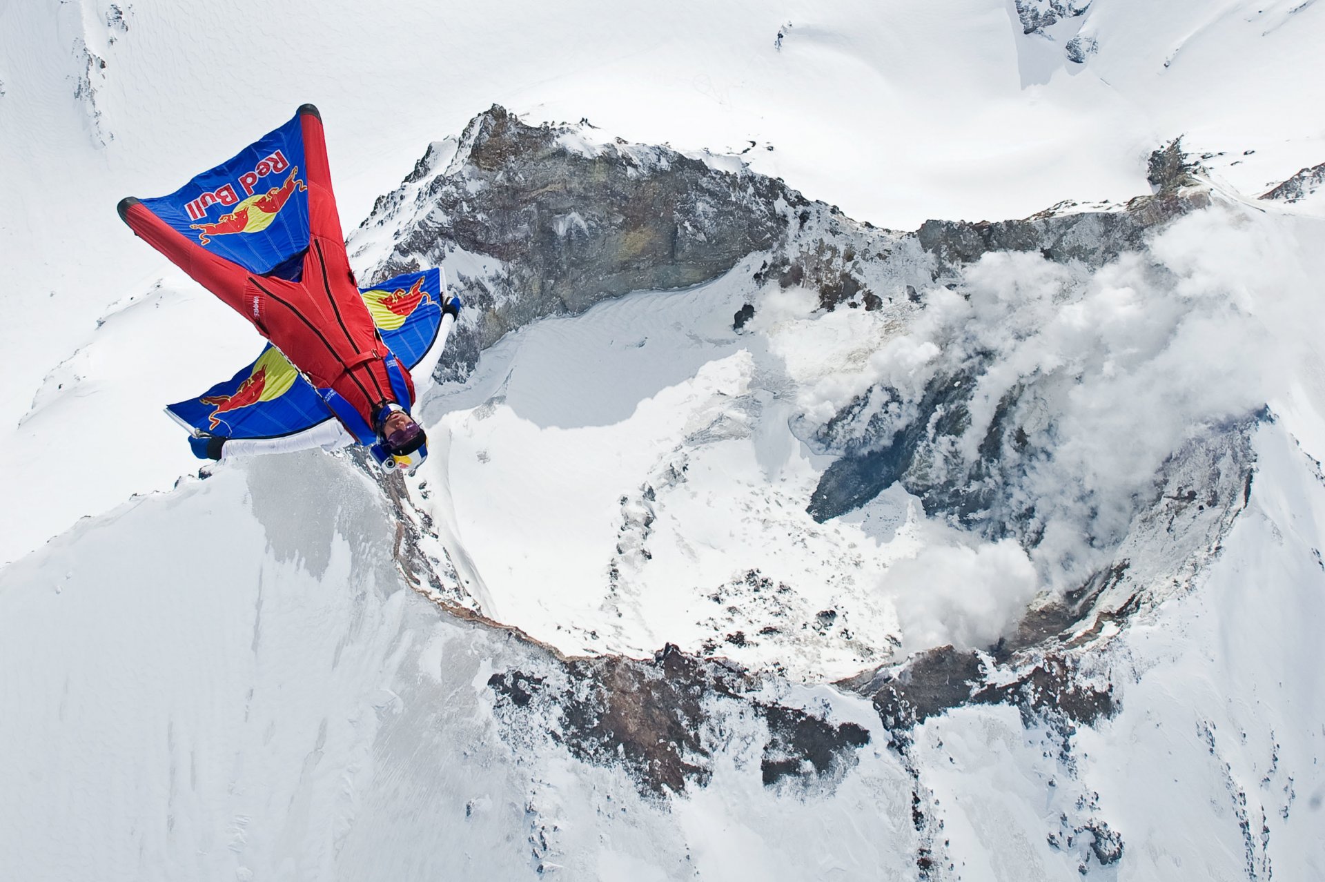 вингсьют пилот летать летчик вулкан гора дым снег зима контейнер парашют красный бык экстремальный спорт