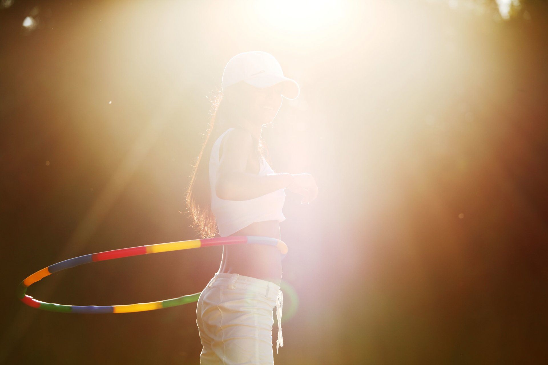 спорт девушка обруч хулахуп фигура движение вращение занятие кепка бейсболка солнце лучи фон обои широкоформатные полноэкранные широкоэкранные