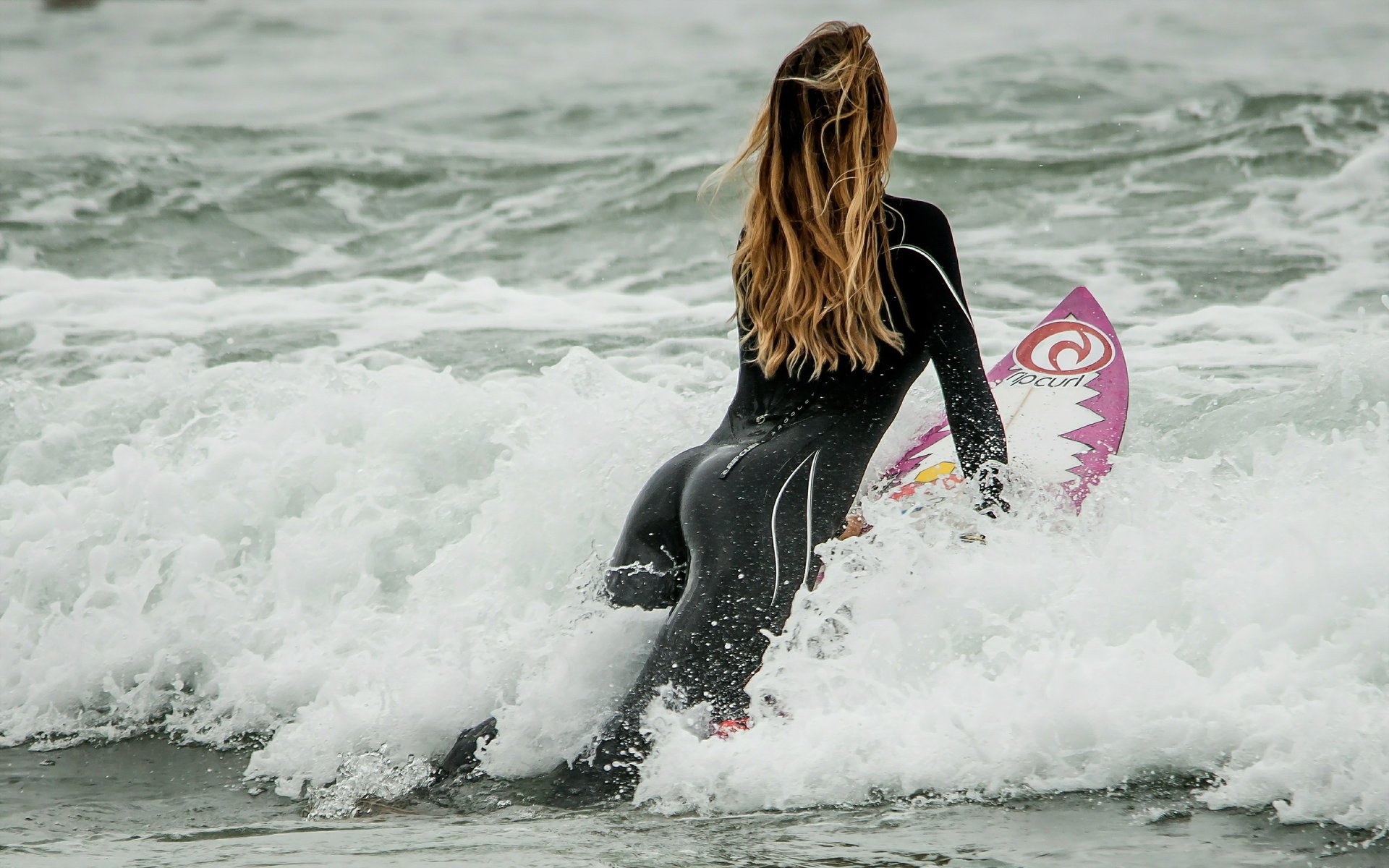 Девушка на доске для сёрфинга в волнах