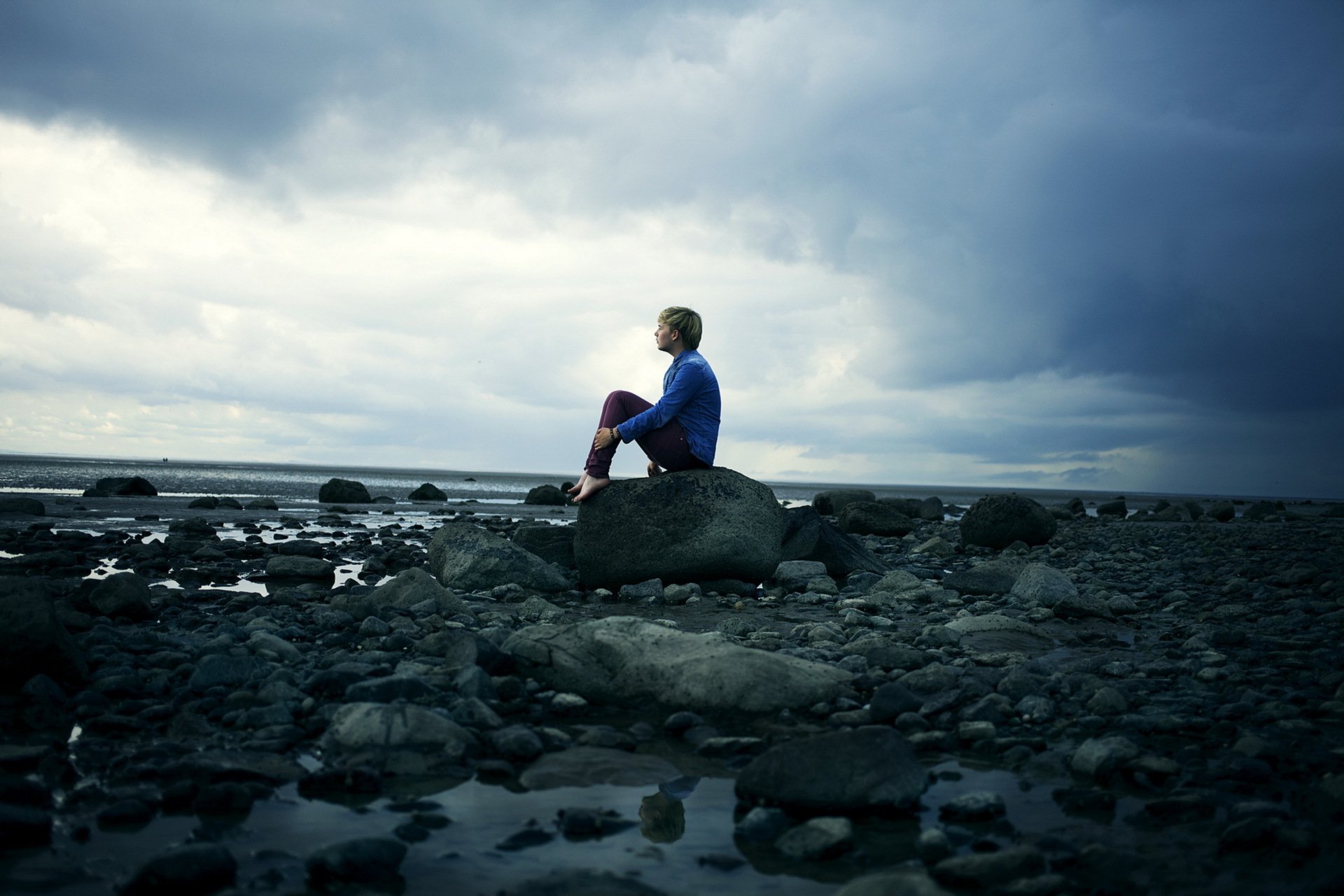Охраны человеческой жизни на море. Одинокий парень. Человек камень. Одинокое море. Человек сидит на берегу.