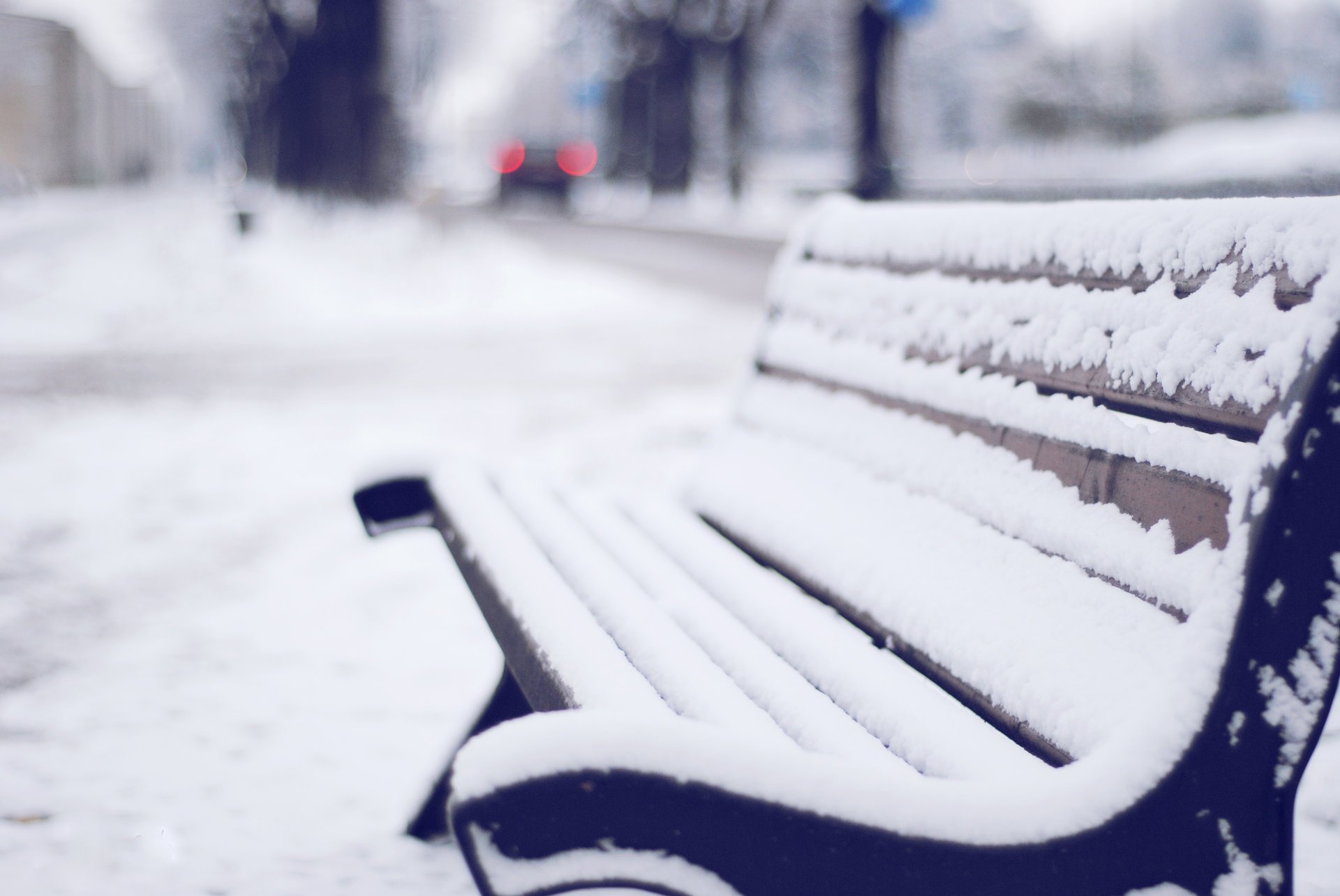 Зимняя скамейка, одиноко стоящая у дороги