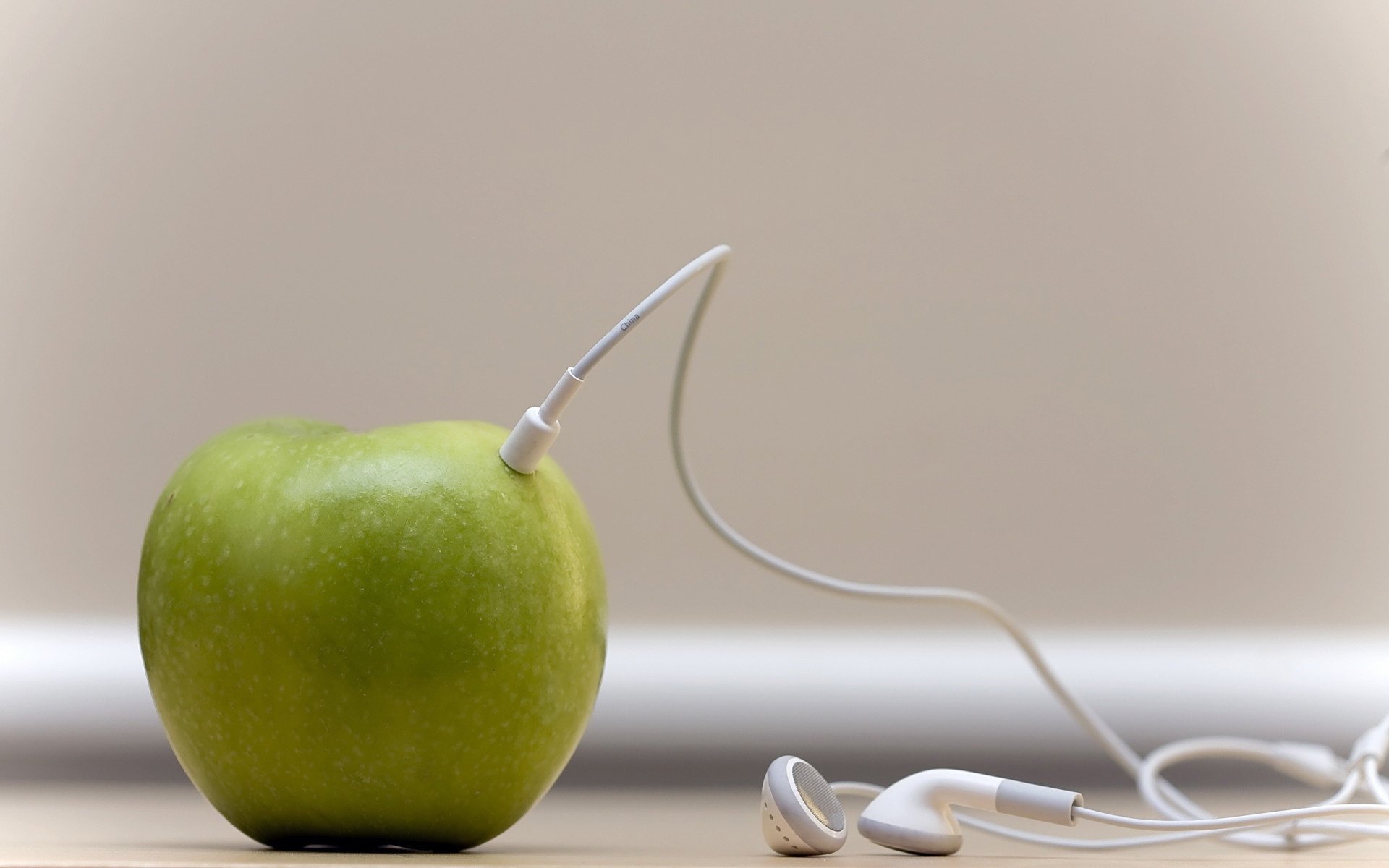 Позитивное яблоко слушает музыку